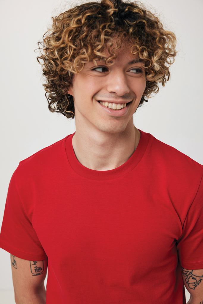 Jeune homme souriant aux cheveux bouclés, t-shirt rouge