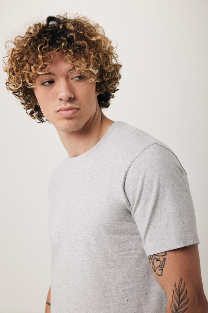 Jeune homme aux cheveux bouclés en t-shirt gris