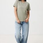 Femme souriante en t-shirt vert et jean clair