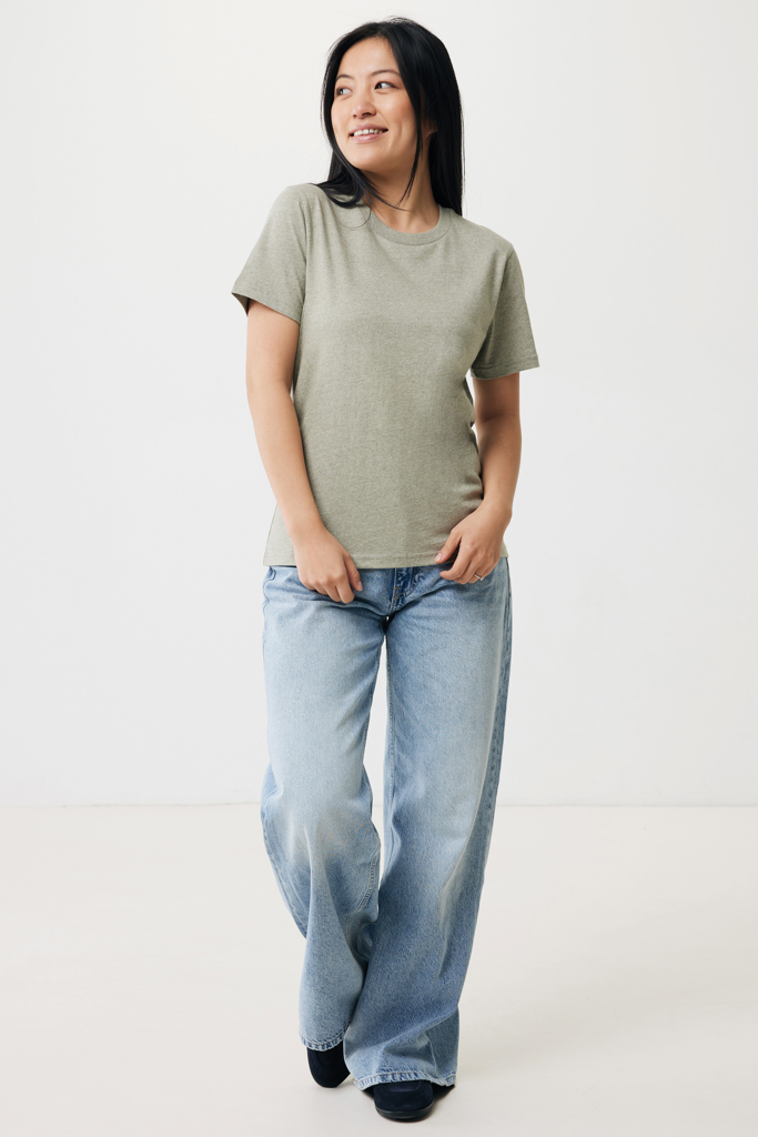 Femme souriante en t-shirt vert et jean clair