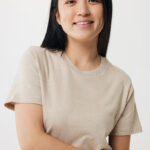 Femme souriante en t-shirt beige sur fond clair