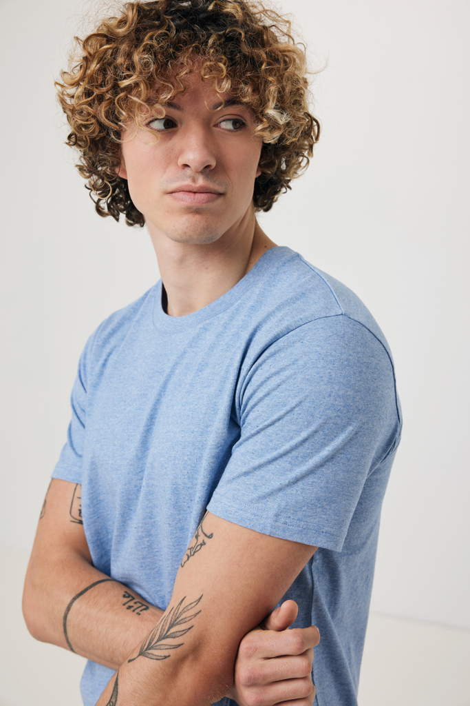 Jeune homme aux cheveux bouclés en t-shirt bleu