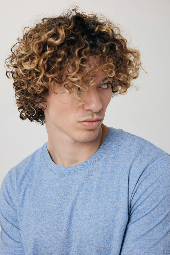 Jeune homme aux cheveux bouclés et mèches blondes