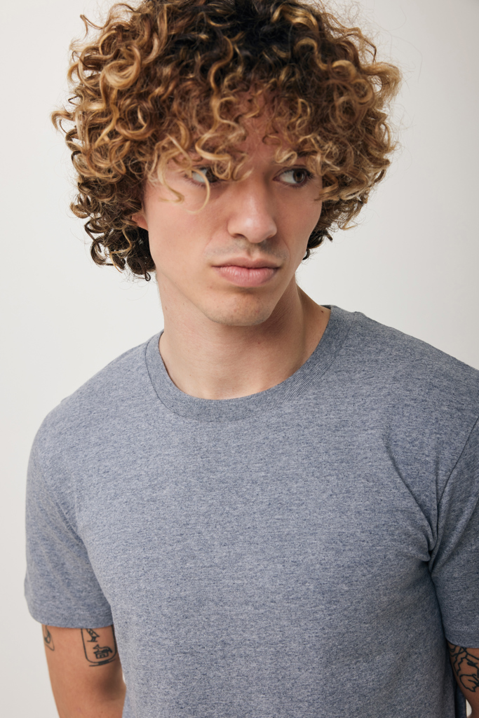 Jeune homme aux cheveux bouclés en t-shirt gris