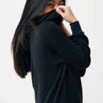Femme en sweat noir couvrant son visage