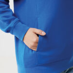 Main dans la poche d’un sweat bleu