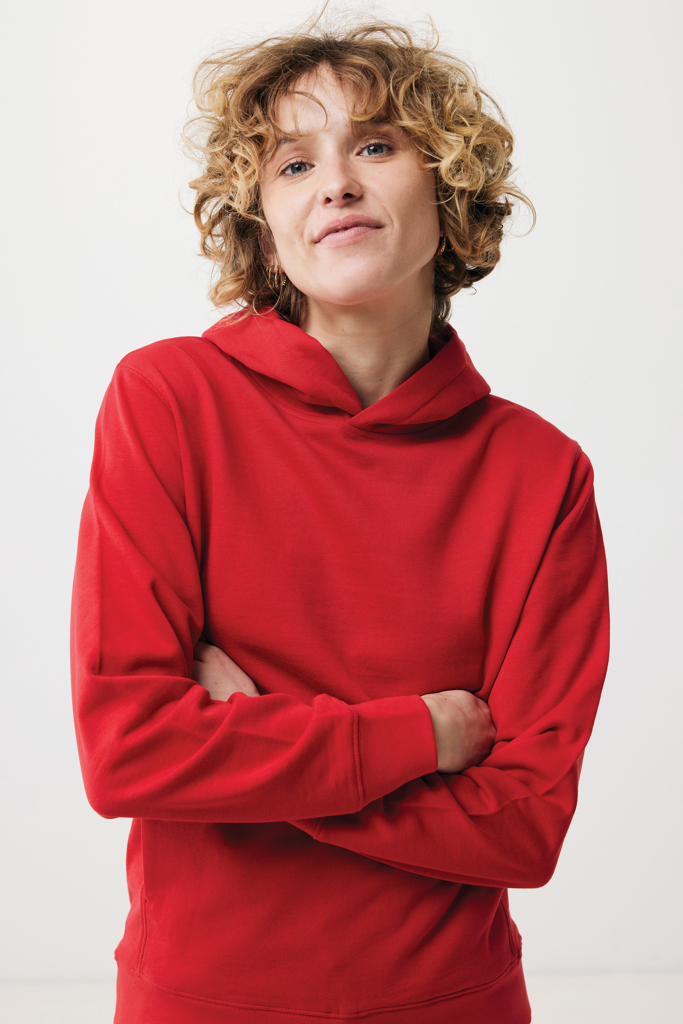 Femme en sweat rouge aux bras croisés