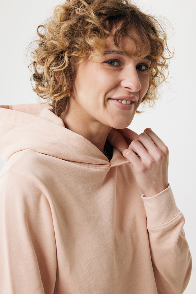 Femme souriante en sweat à capuche rose