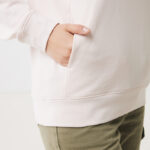 Main dans poche de sweat à capuche beige