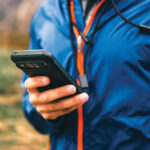 Homme en veste bleue consultant son smartphone