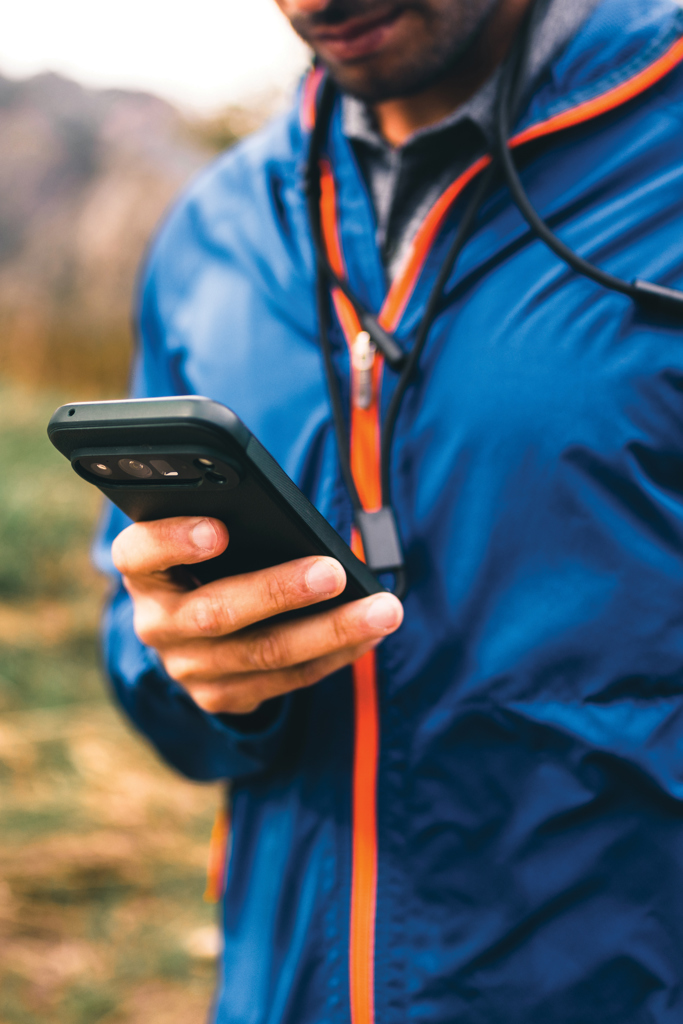 Homme en veste bleue consultant son smartphone