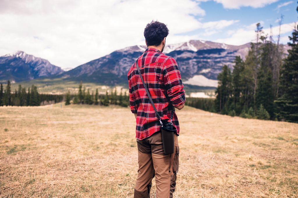 Homme en chemise rouge face aux montagnes
