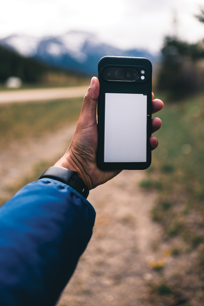 Main tenant smartphone sur sentier de montagne