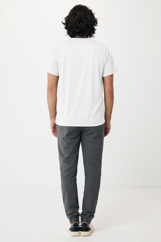 Homme de dos en t-shirt blanc et pantalon gris