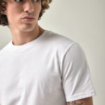 Homme aux cheveux bouclés en t-shirt blanc