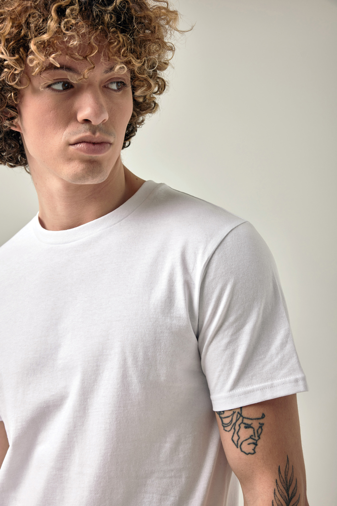 Homme aux cheveux bouclés en t-shirt blanc