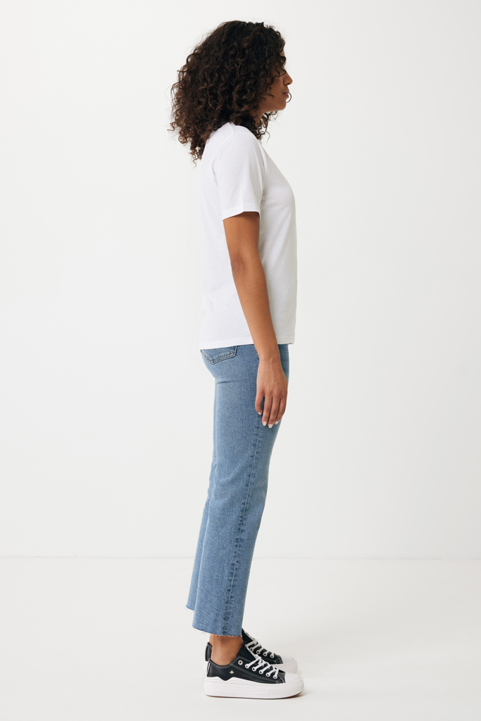 Femme de profil en t-shirt blanc et jean