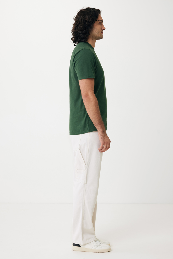 Homme en profil portant t-shirt vert et pantalon blanc