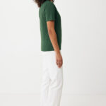 Femme de profil en t-shirt vert et pantalon blanc