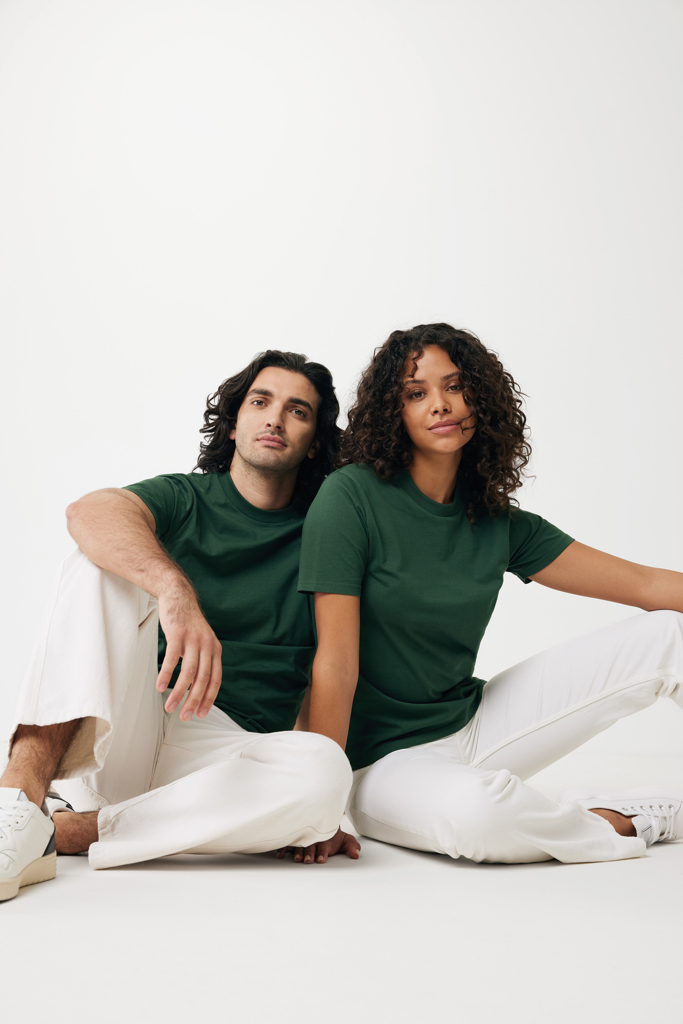 Couple assis en t-shirts verts et pantalons blancs