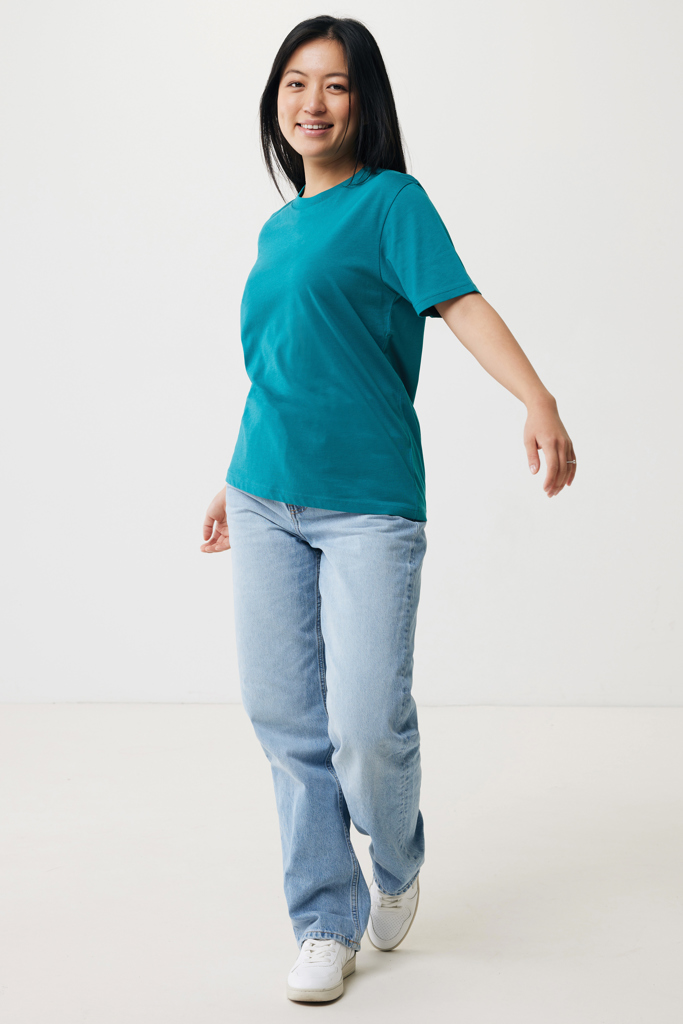 Femme marchant en t-shirt vert et jean clair