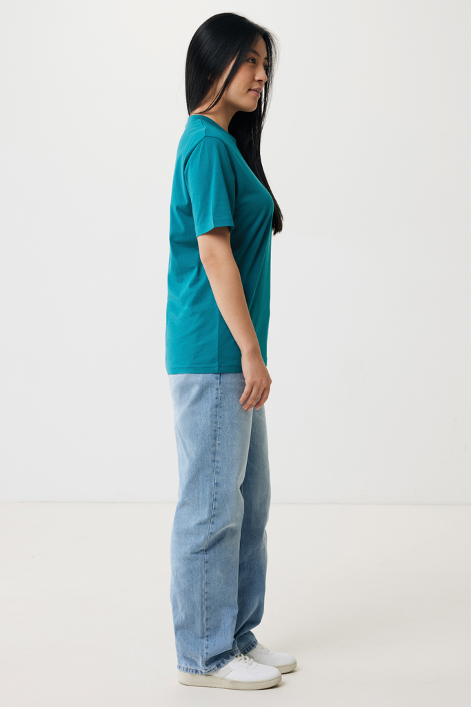 Femme de profil en t-shirt vert et jean