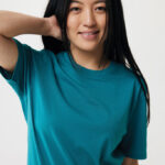 Femme souriante en t-shirt vert sur fond neutre