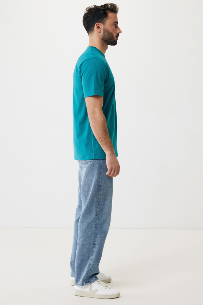 Homme de profil en t-shirt vert et jean
