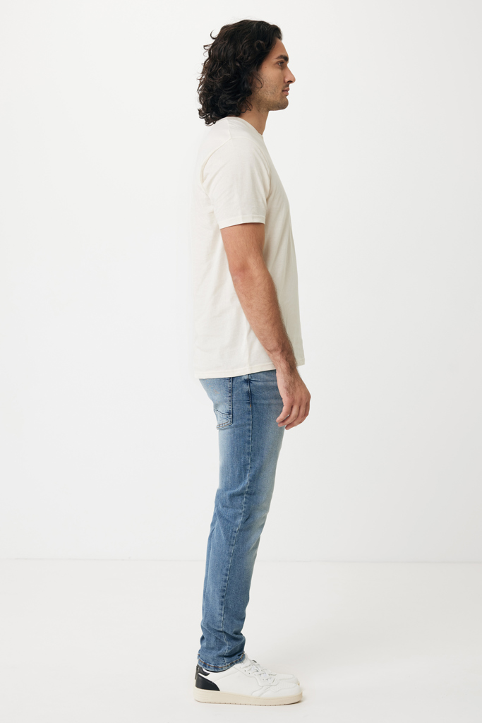 Homme de profil en t-shirt beige et jean