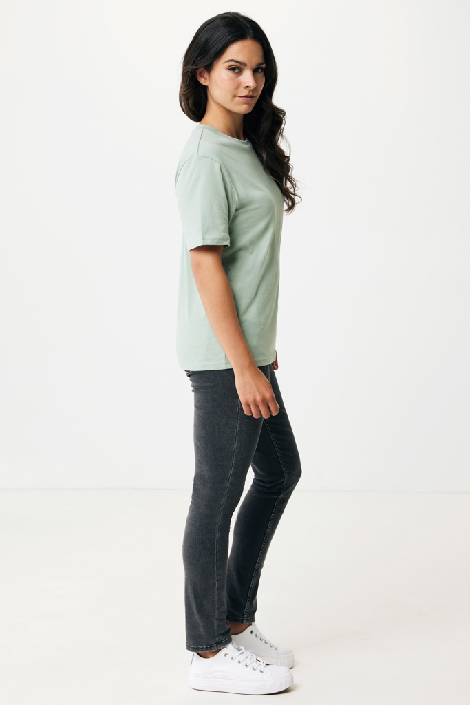 Femme en t-shirt vert et jean gris