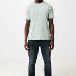 Homme souriant en t-shirt vert et jean foncé