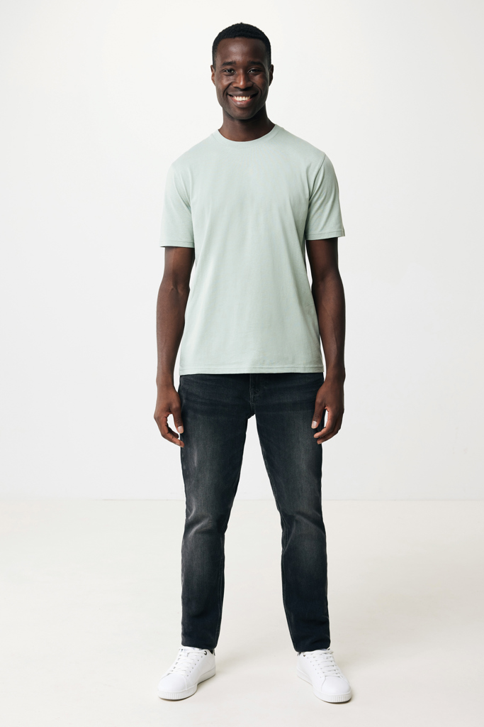 Homme souriant en t-shirt vert et jean foncé