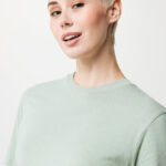 Femme aux cheveux courts blonds en t-shirt vert