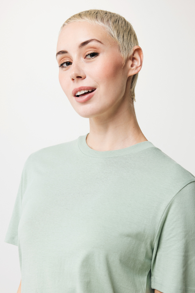Femme aux cheveux courts blonds en t-shirt vert