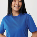 Femme souriante en t-shirt bleu sur fond neutre