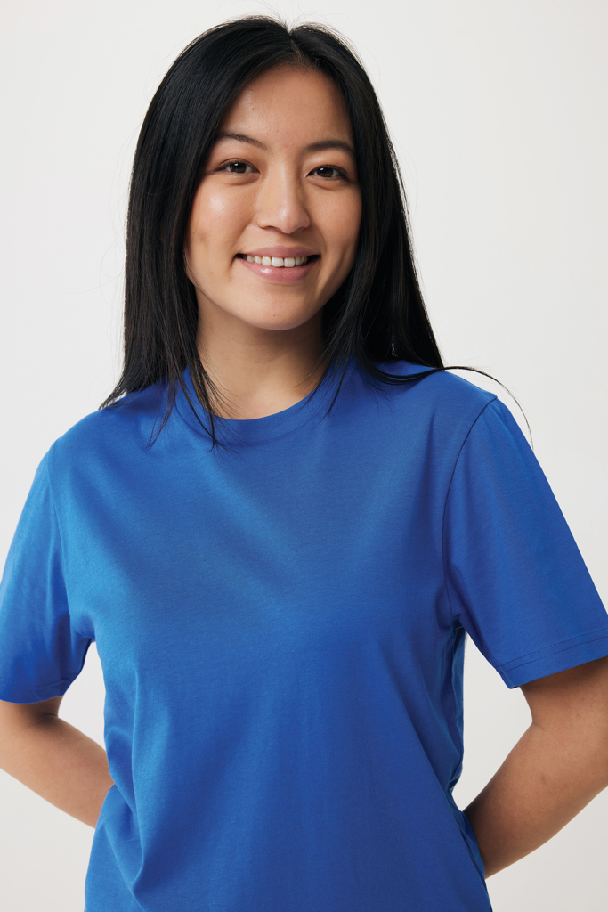 Femme souriante en t-shirt bleu sur fond neutre