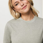 Femme blonde souriante en t-shirt gris clair