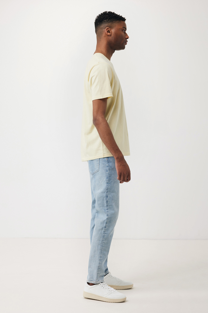 Homme de profil en t-shirt beige et jean