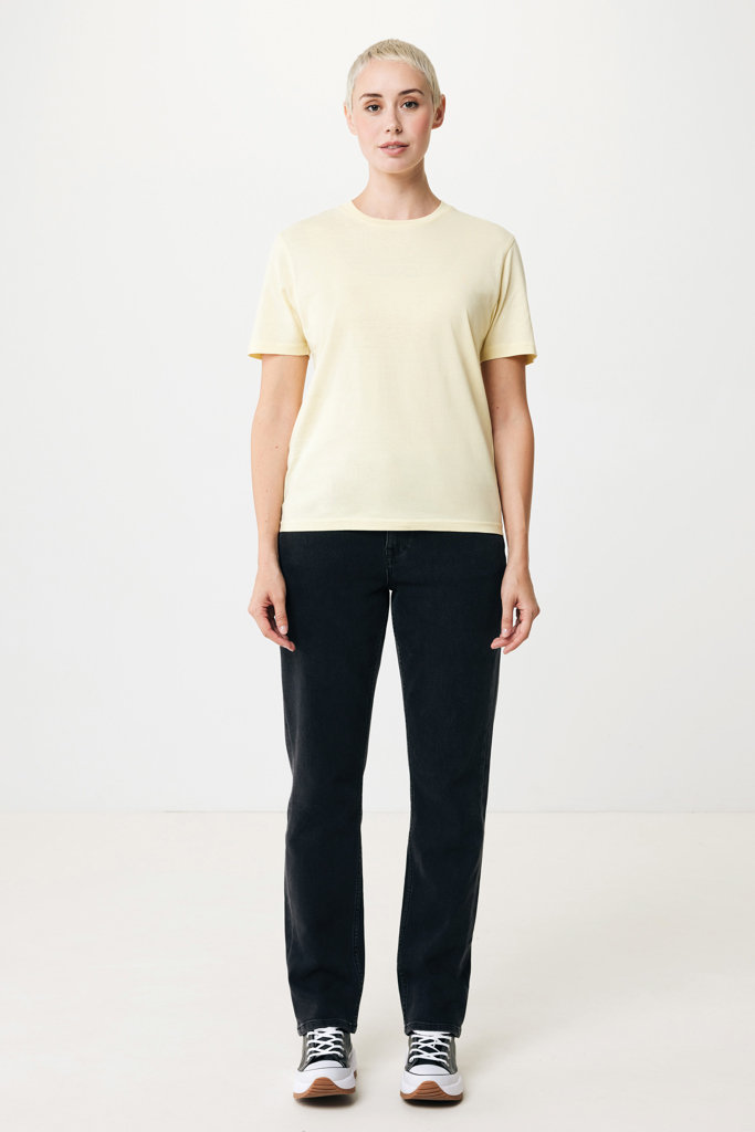 Femme en t-shirt beige et jean noir, baskets blanches