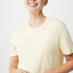 Femme souriante aux cheveux courts blonds en t-shirt jaune