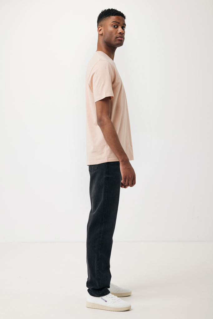 Homme en t-shirt beige et jean noir