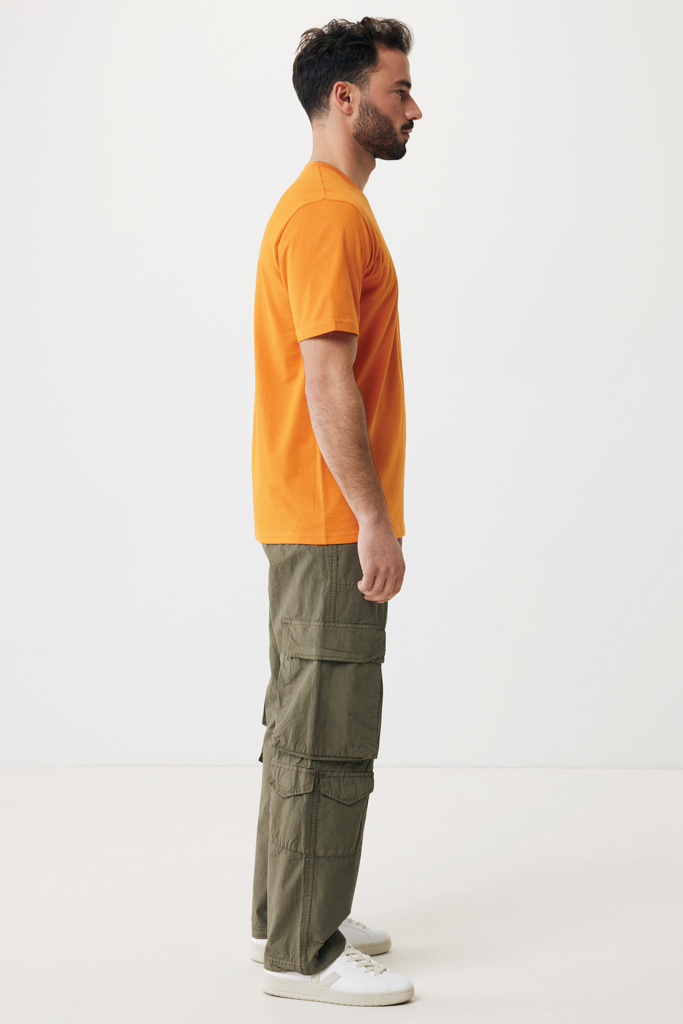 Homme de profil en t-shirt orange et cargo