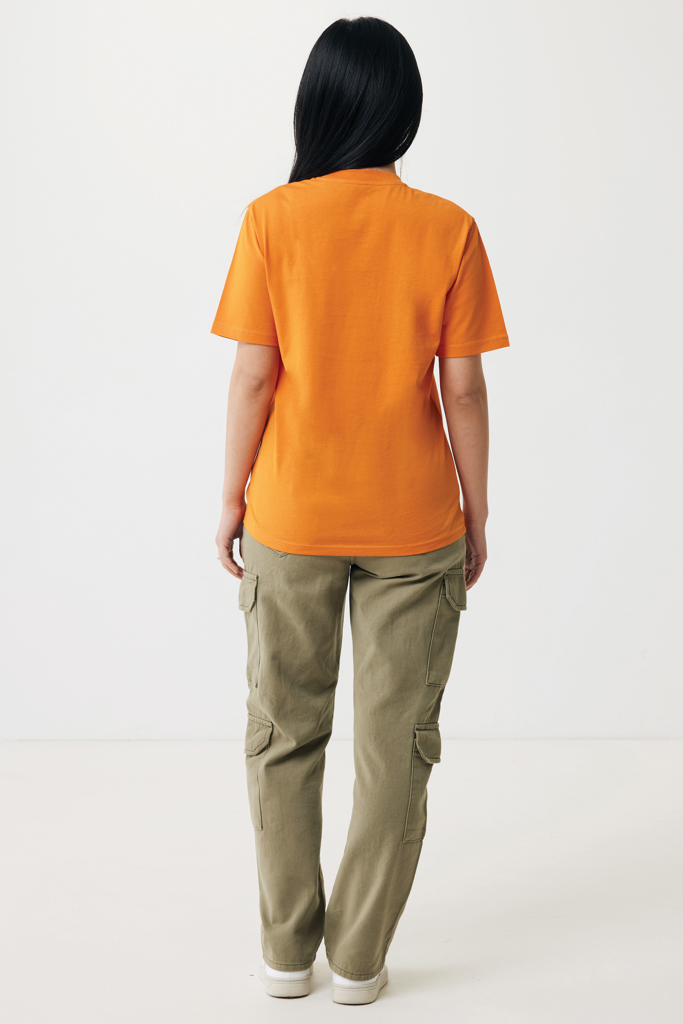 Femme de dos en t-shirt orange, pantalon cargo kaki