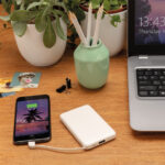 Smartphone en charge sur bureau avec ordinateur portable