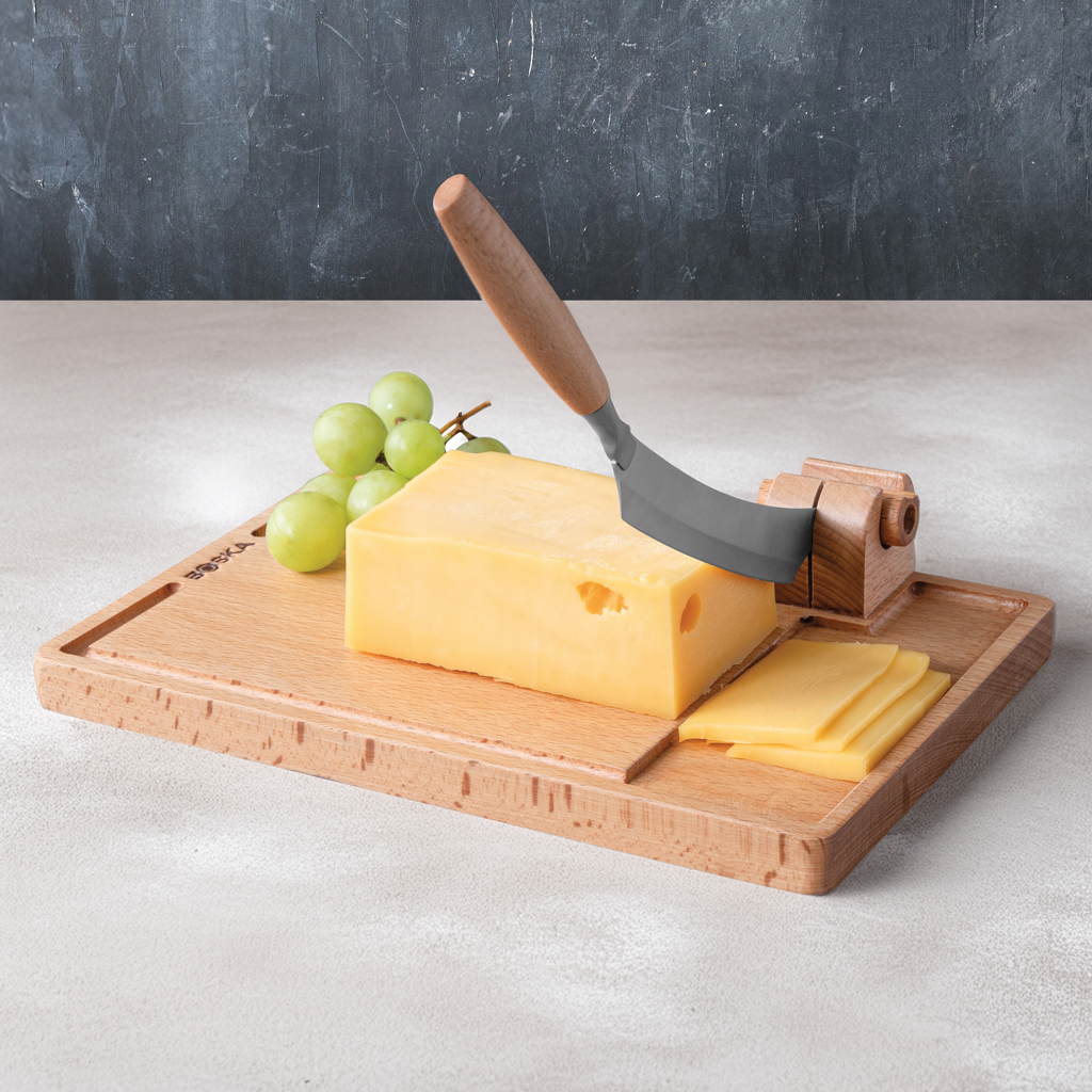 Bloc de fromage avec trancheuse et raisins verts