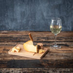 Fromage sur planche avec verre de vin blanc