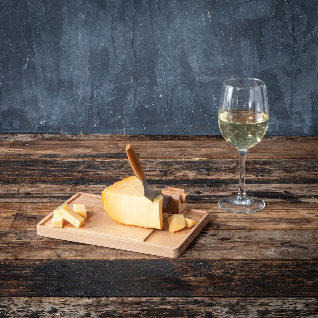Fromage sur planche avec verre de vin blanc