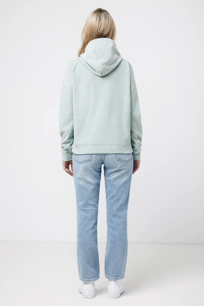 Femme de dos en hoodie vert pâle et jean clair