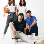 Quatre jeunes en tenue sportive posant ensemble