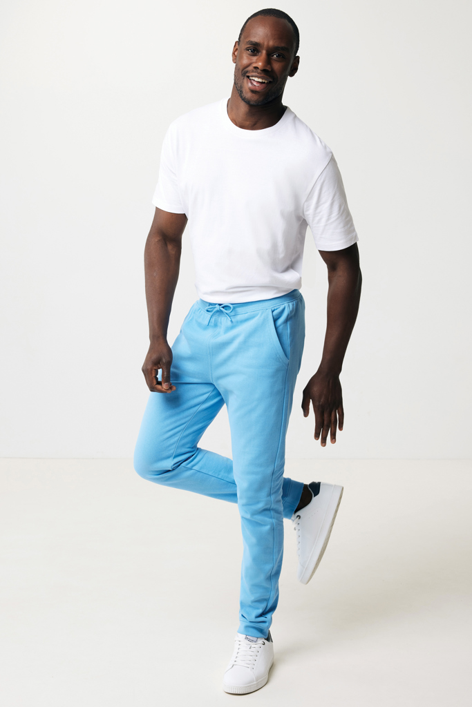 Homme souriant en t-shirt blanc et jogging bleu